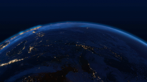 Striking satellite view of Earth at night showcasing city lights, atmospheric glow, and the planet’s curvature.